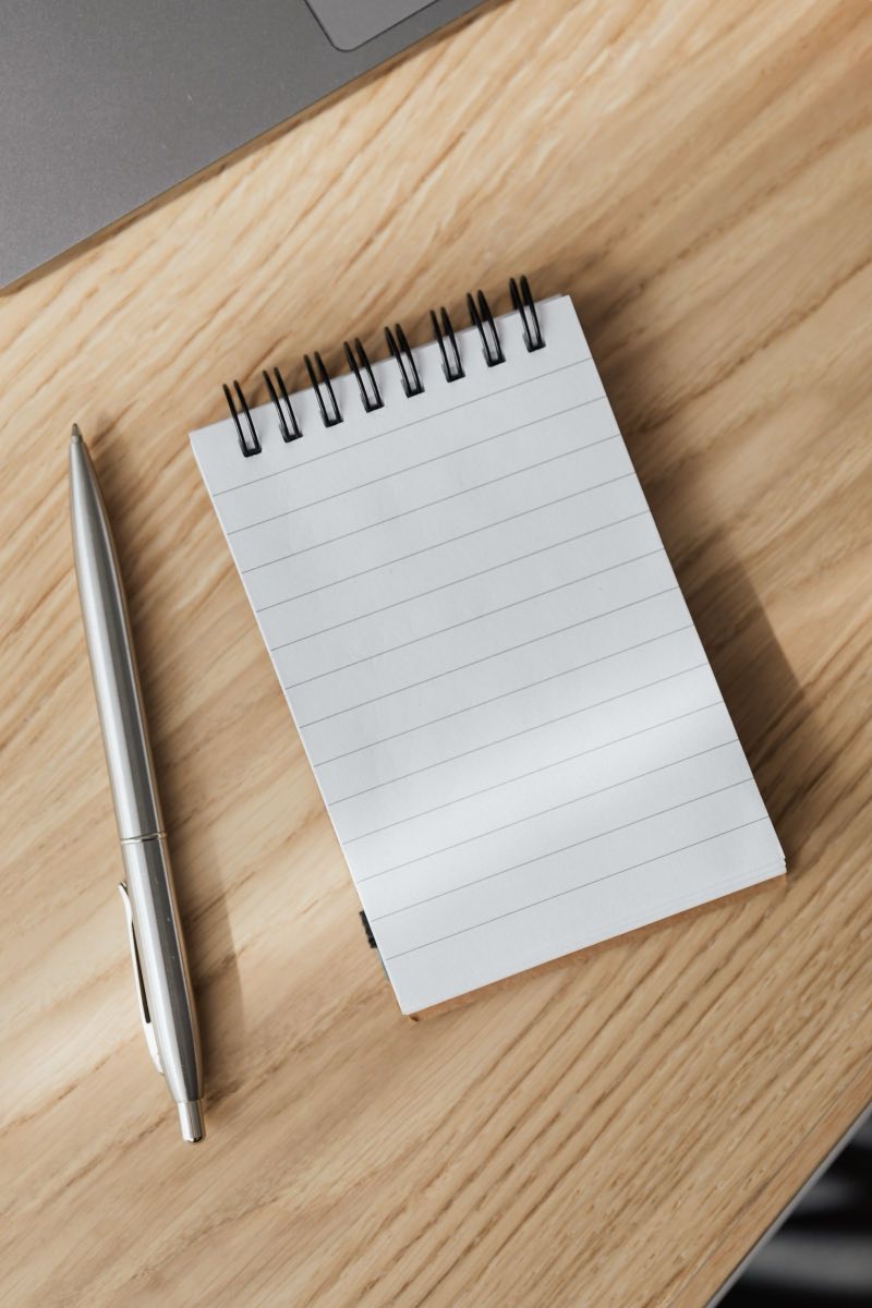 A blank notepad with a pen beside it, waiting to be written on