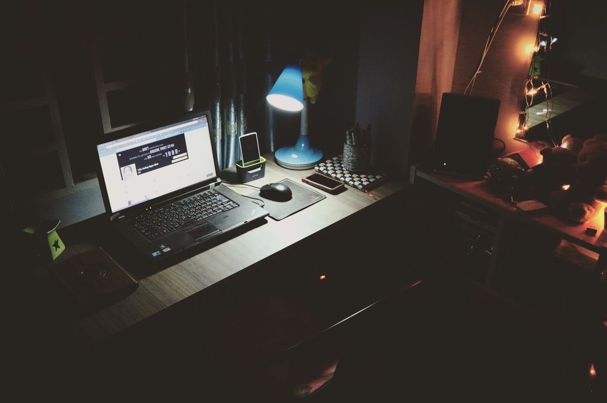 A laptop glowing on a desk at night