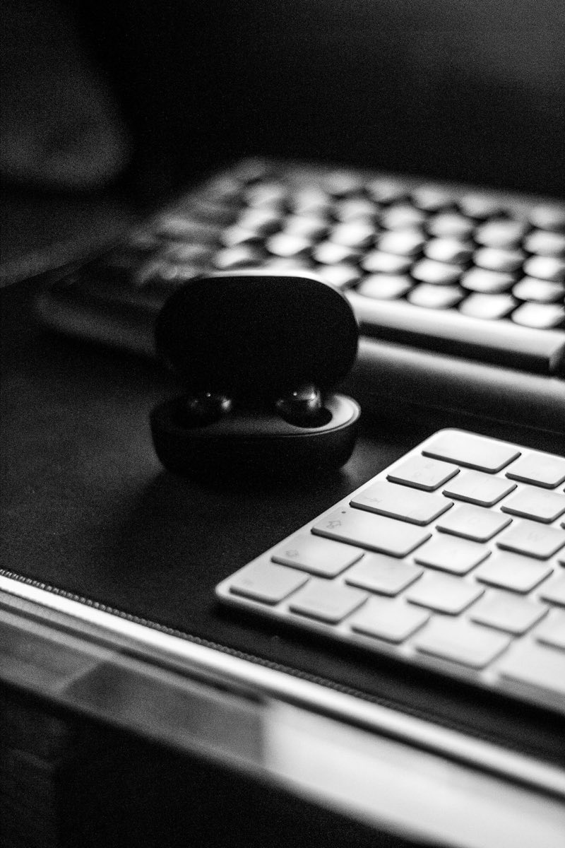 Earphones resting on a desk beside a keyboard