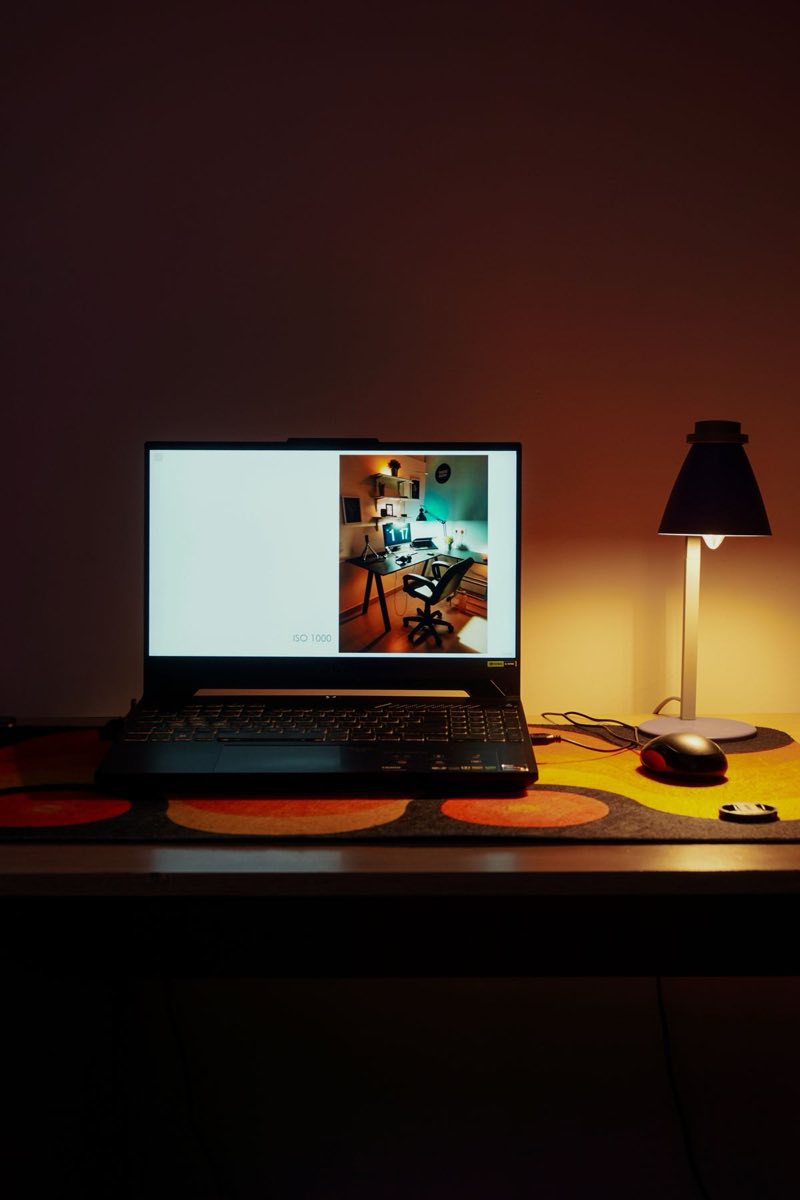 One laptop and one lamp on an otherwise quiet desk